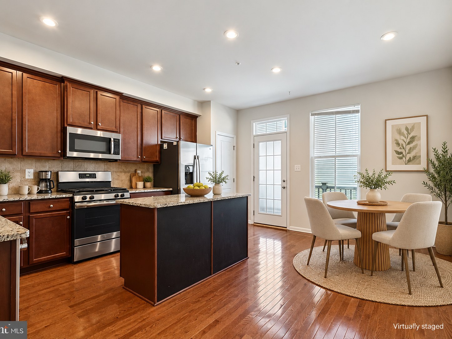 Kitchen and dining area with an island and warm wood floors