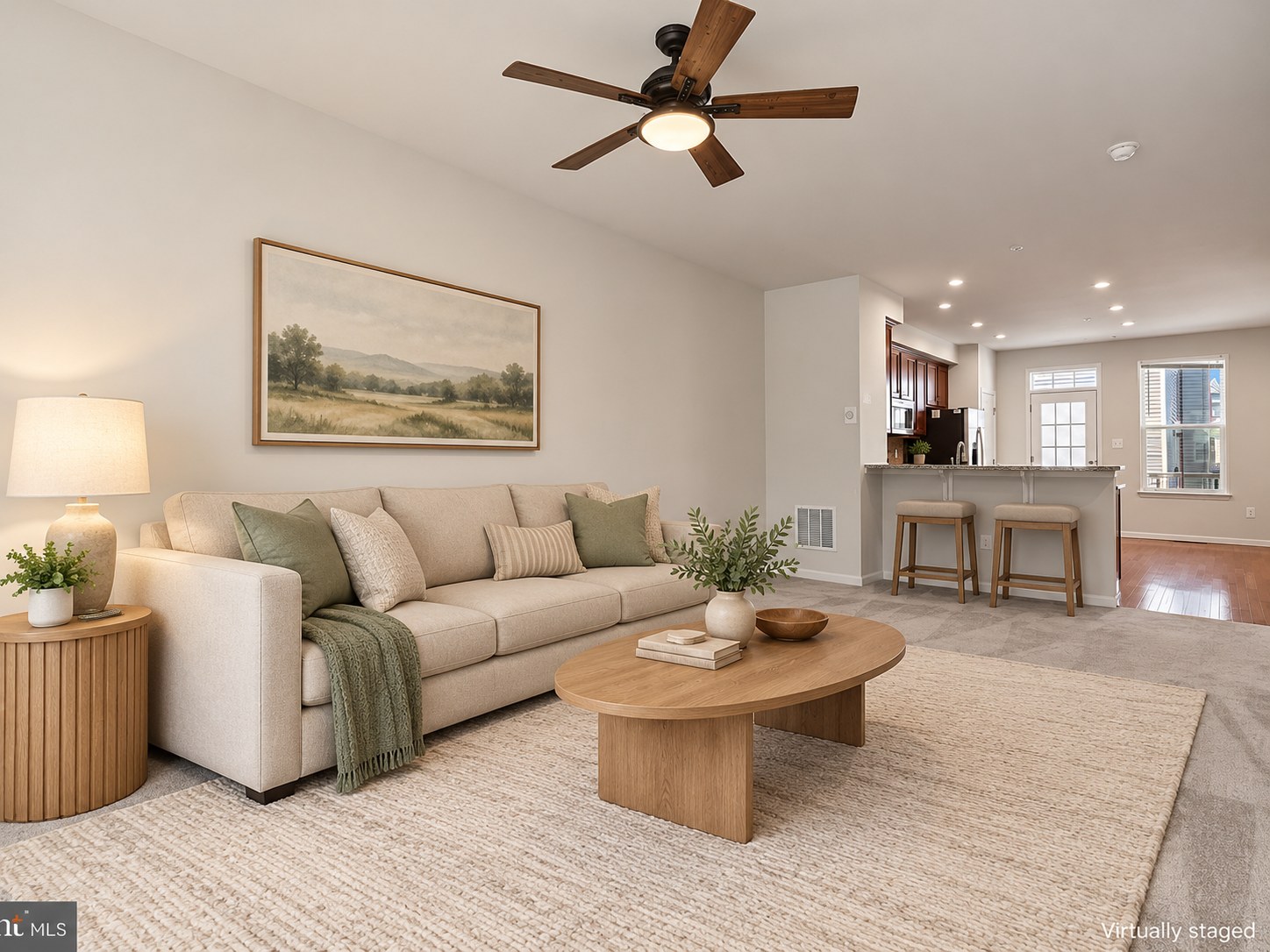 Open living room with a sofa, wood coffee table, and kitchen beyond